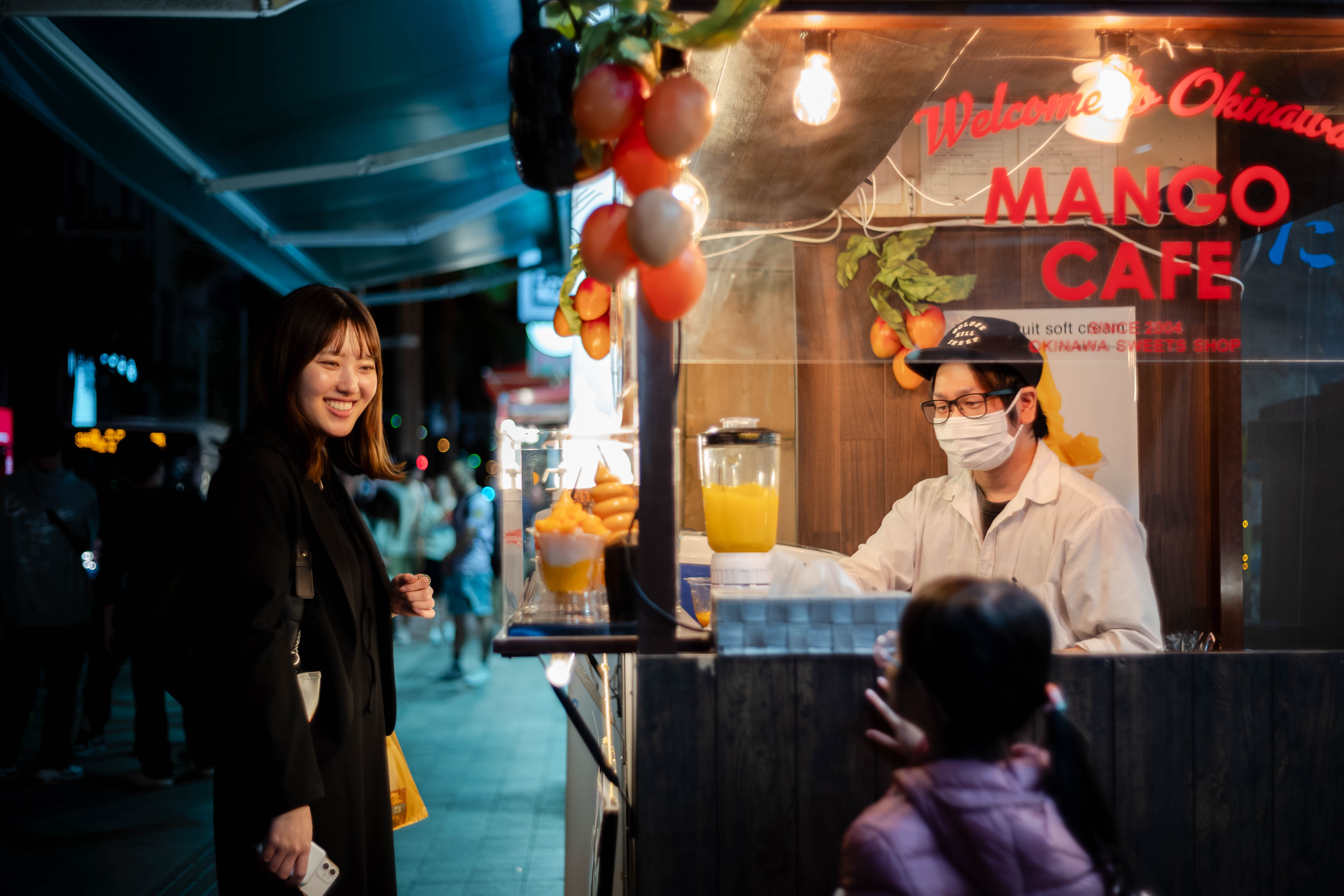 沖縄でマンゴージュースを買う中川小雪さんの画像